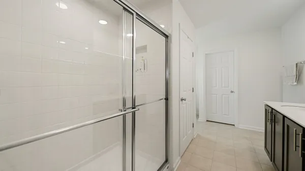 a bathroom with a shower and a glass door