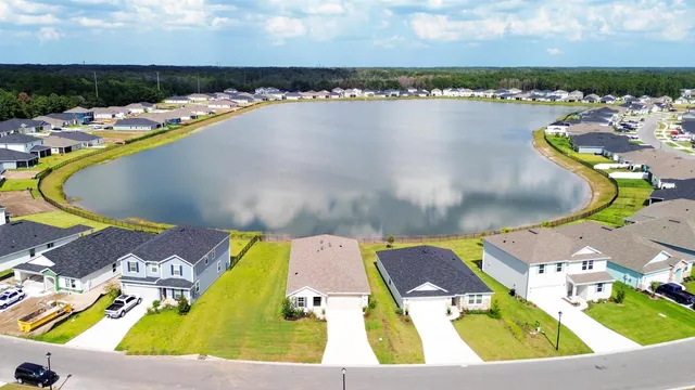an aerial view of a swimming pool with outdoor seating and yard