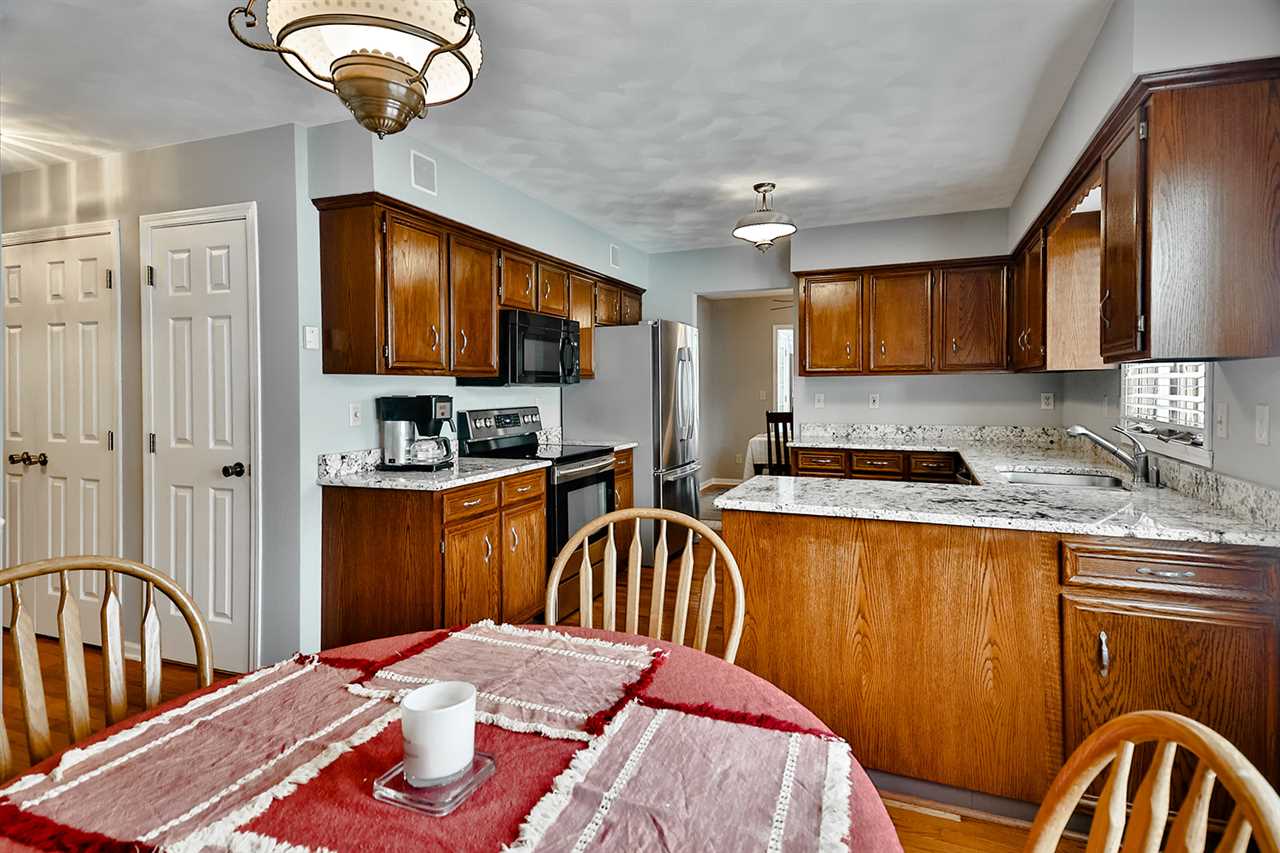 8112 McCurry Road Roscoe, IL 61073 - Photo 16 of 30 a kitchen with stainless steel appliances granite countertop a sink dishwasher a refrigerator with wooden cabinets and floor