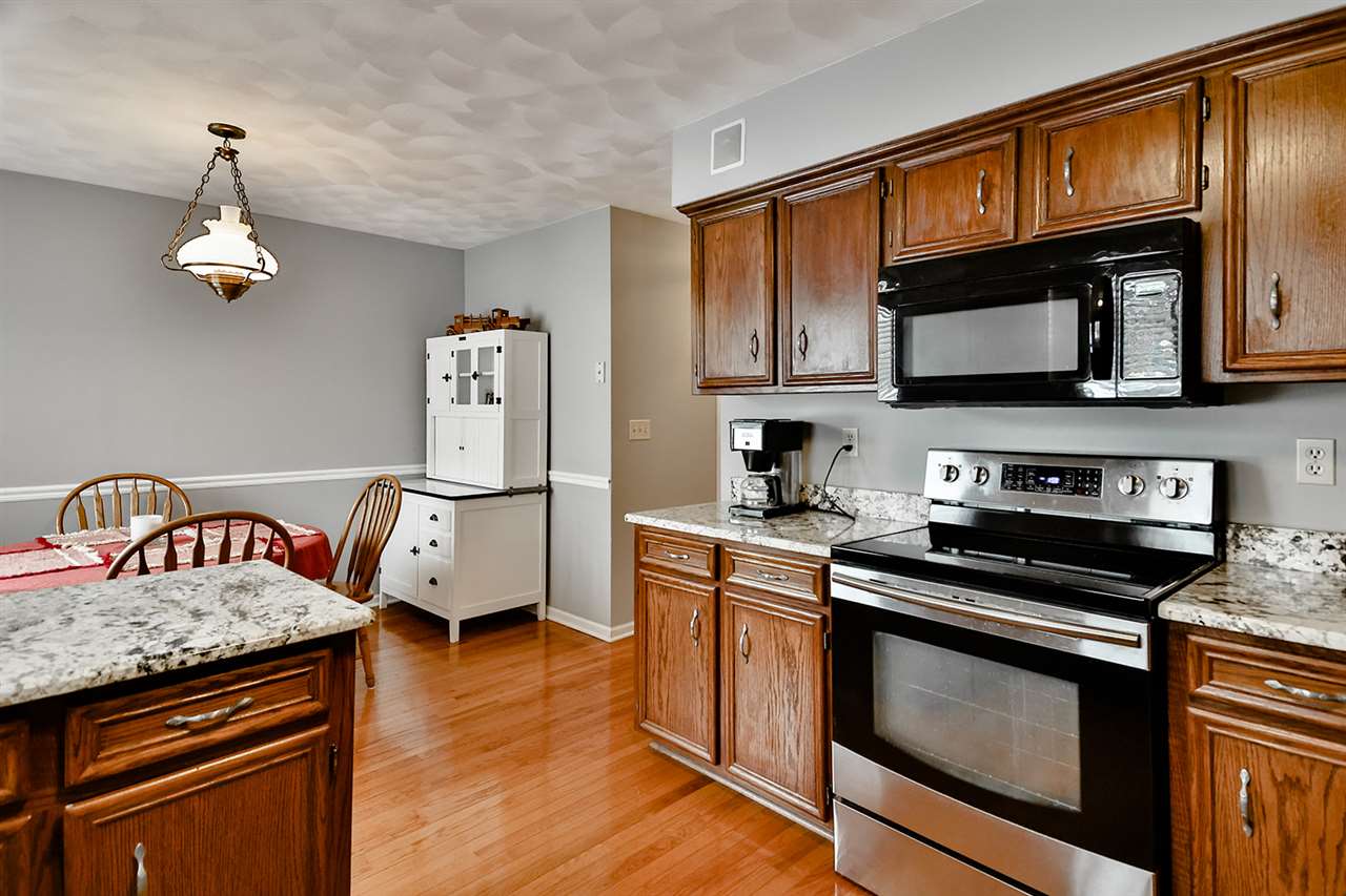 8112 McCurry Road Roscoe, IL 61073 - Photo 18 of 30 a kitchen with granite countertop stainless steel appliances and wooden cabinets