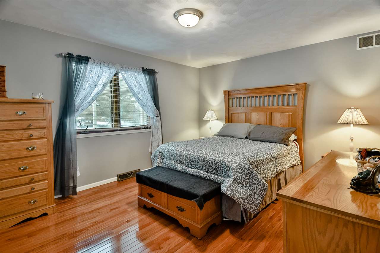 8112 McCurry Road Roscoe, IL 61073 - Photo 25 of 30 a bedroom with a bed and a dresser next to a window
