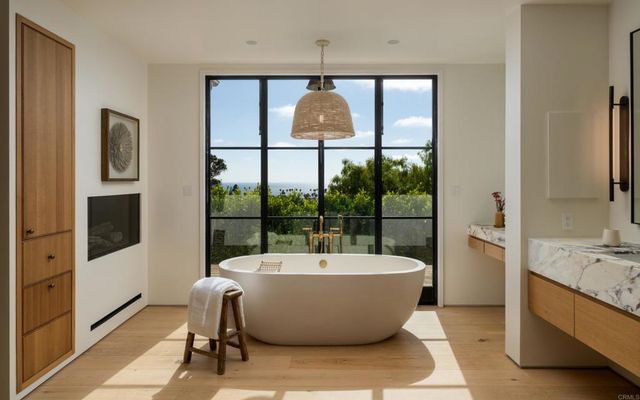 a large tub sitting in a bathroom next to a large window
