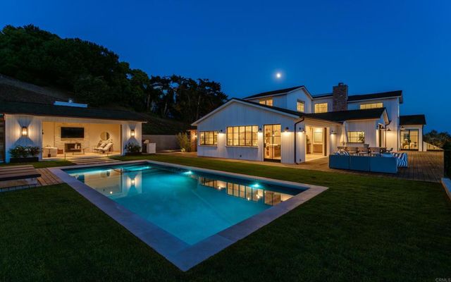 a view of a backyard with a patio and swimming pool