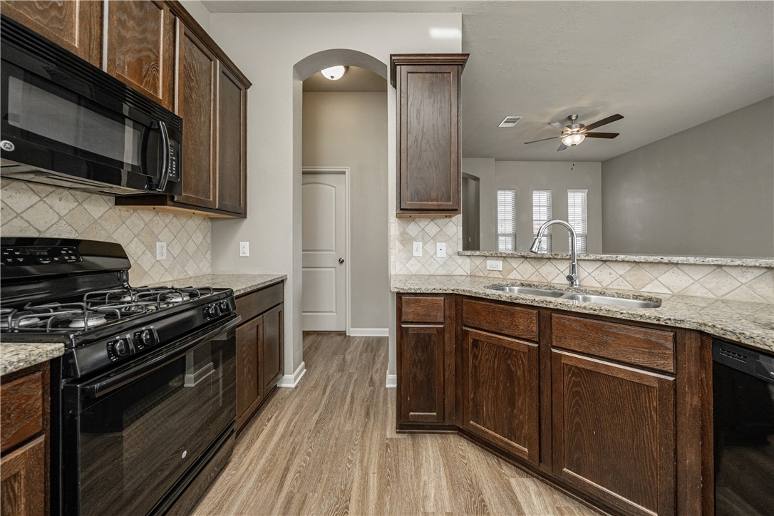 3009 Positano Loop Bryan, TX 77808 - Photo 9 of 21 a kitchen with stainless steel appliances granite countertop a stove a sink and a microwave