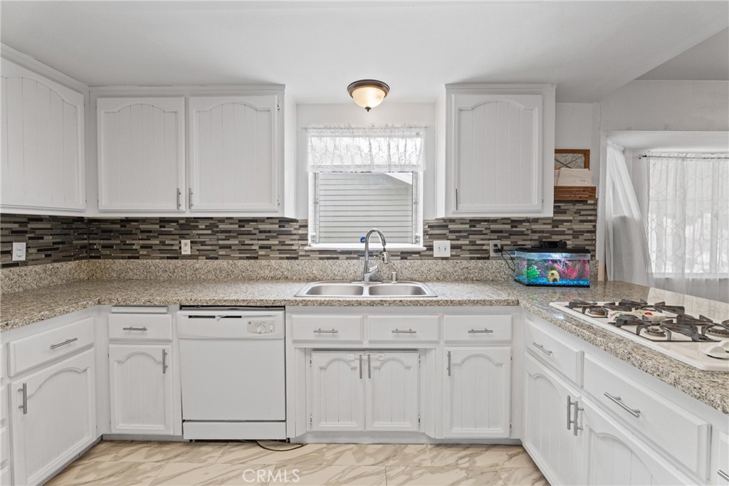 14610 Apple Valley Road Apple Valley, CA 92307 - Photo 17 of 49 a kitchen with white cabinets appliances and a window