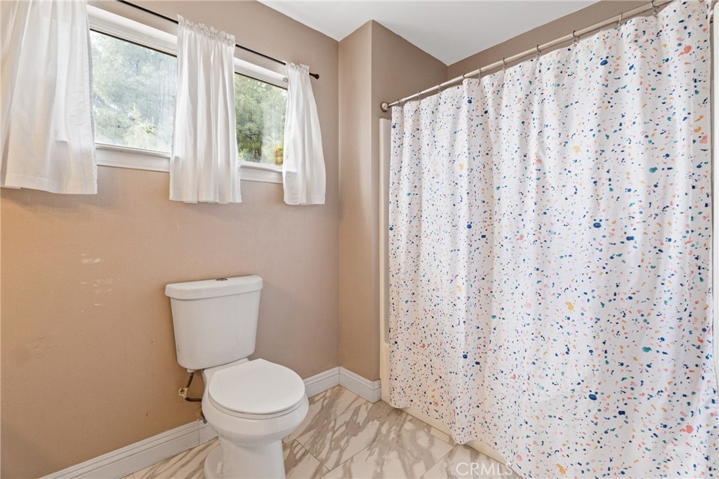 14610 Apple Valley Road Apple Valley, CA 92307 - Photo 36 of 49 a white toilet sitting next to a window in a bathroom