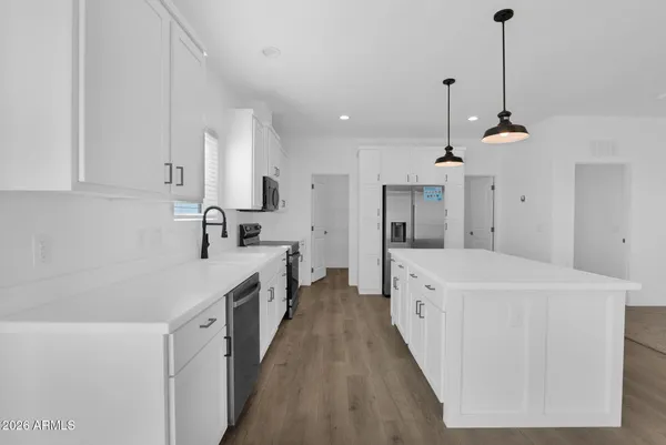 a view of kitchen with kitchen island stainless steel appliances refrigerator stove microwave and cabinets