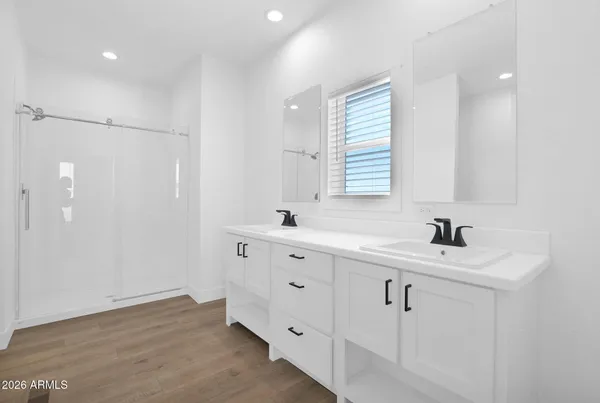 a large white kitchen with a sink a counter top space stainless steel appliances and a chandelier