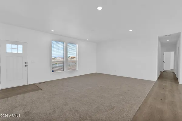 an empty room with white walls and windows