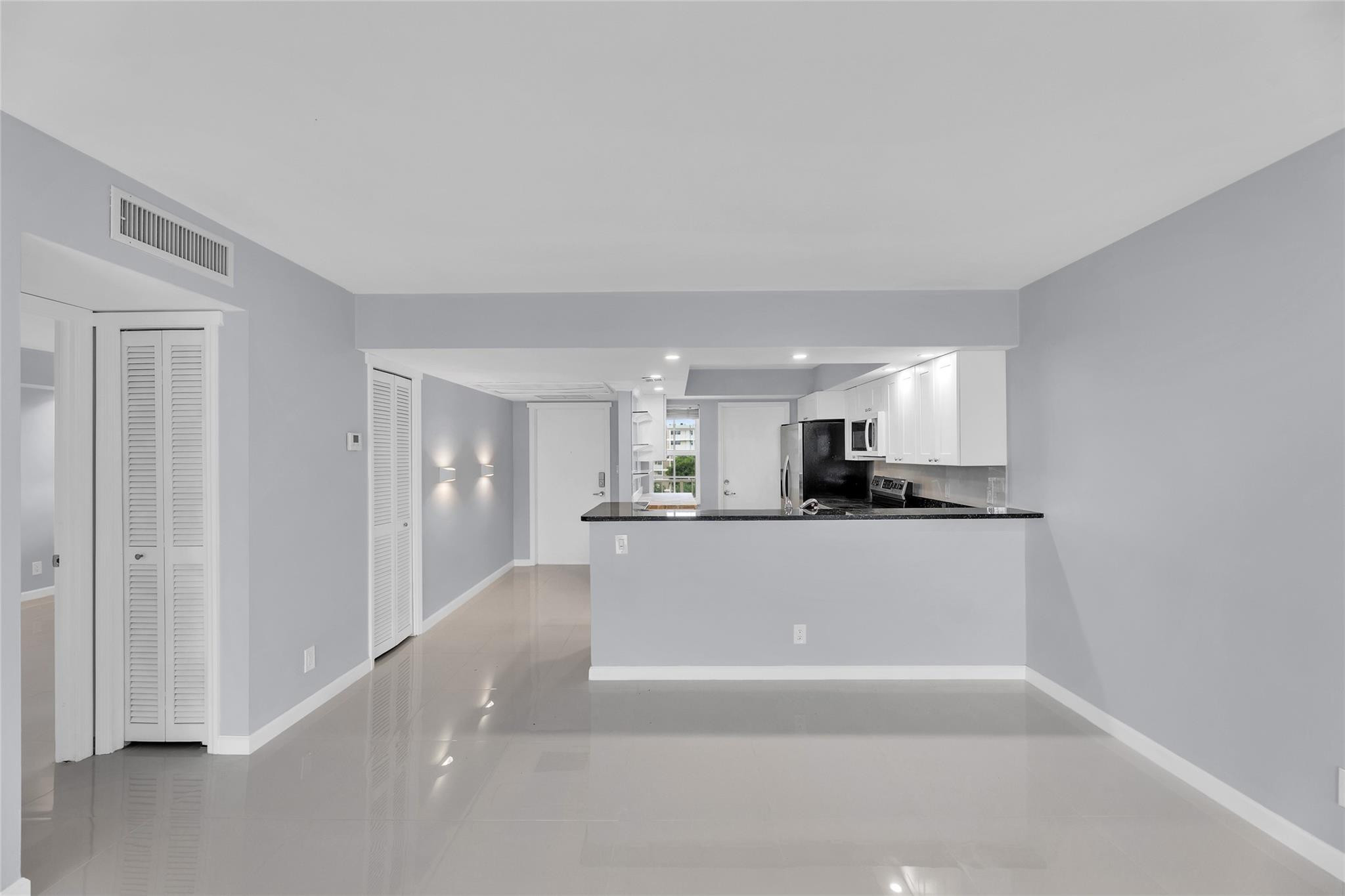 3090 North Course Drive, Unit 609 Pompano Beach, FL 33069 - Photo 11 of 44 a living room with stainless steel appliances a sink a microwave a refrigerator and cabinets