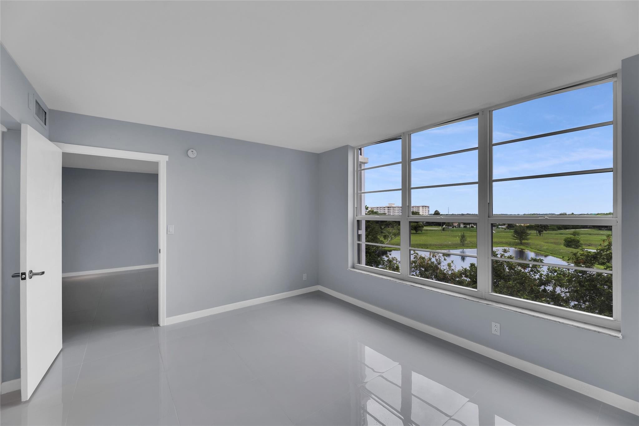3090 North Course Drive, Unit 609 Pompano Beach, FL 33069 - Photo 23 of 44 an empty room with wooden floor and a window