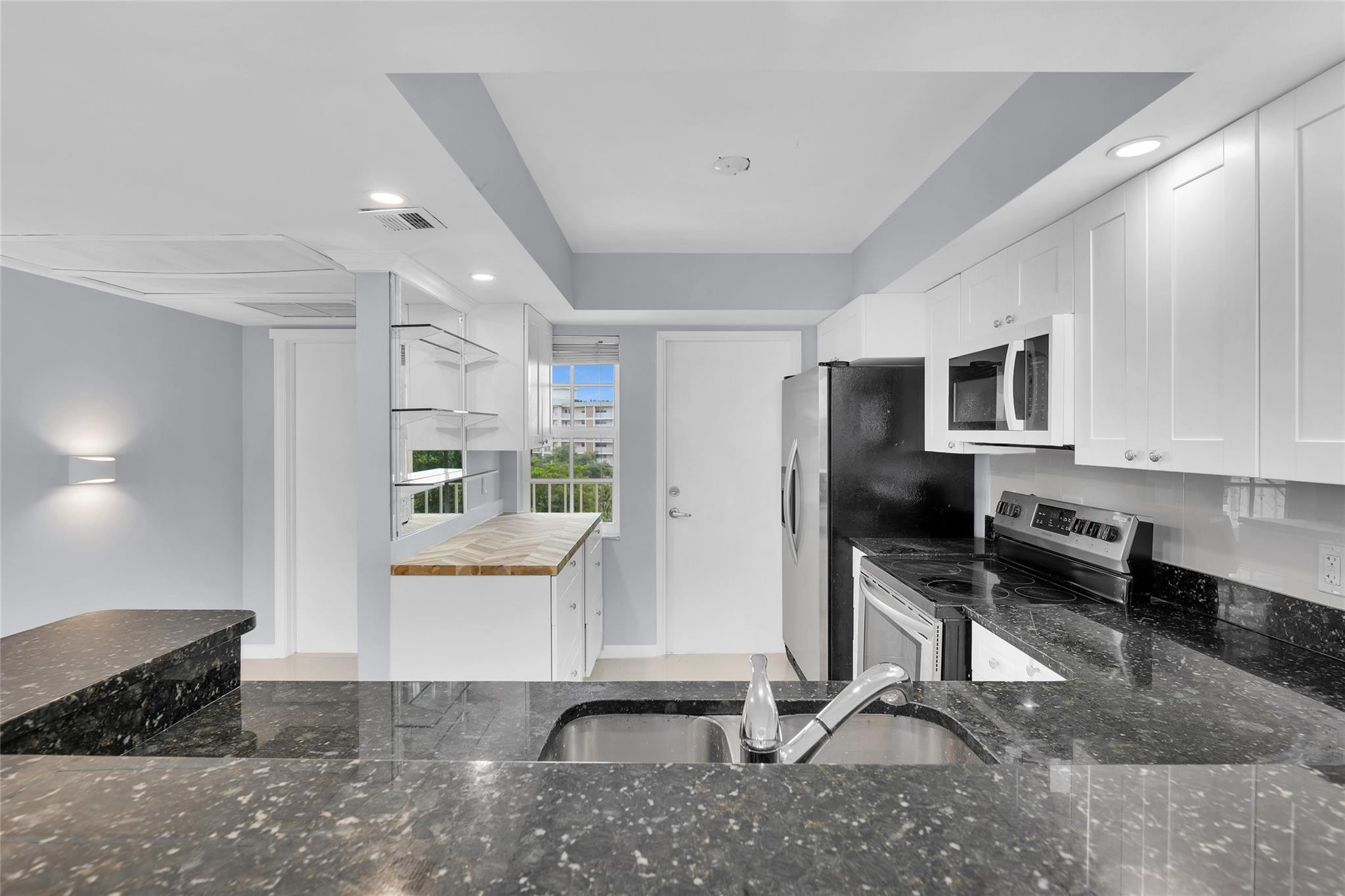 3090 North Course Drive, Unit 609 Pompano Beach, FL 33069 - Photo 3 of 44 a living room with furniture a flat screen tv and kitchen view
