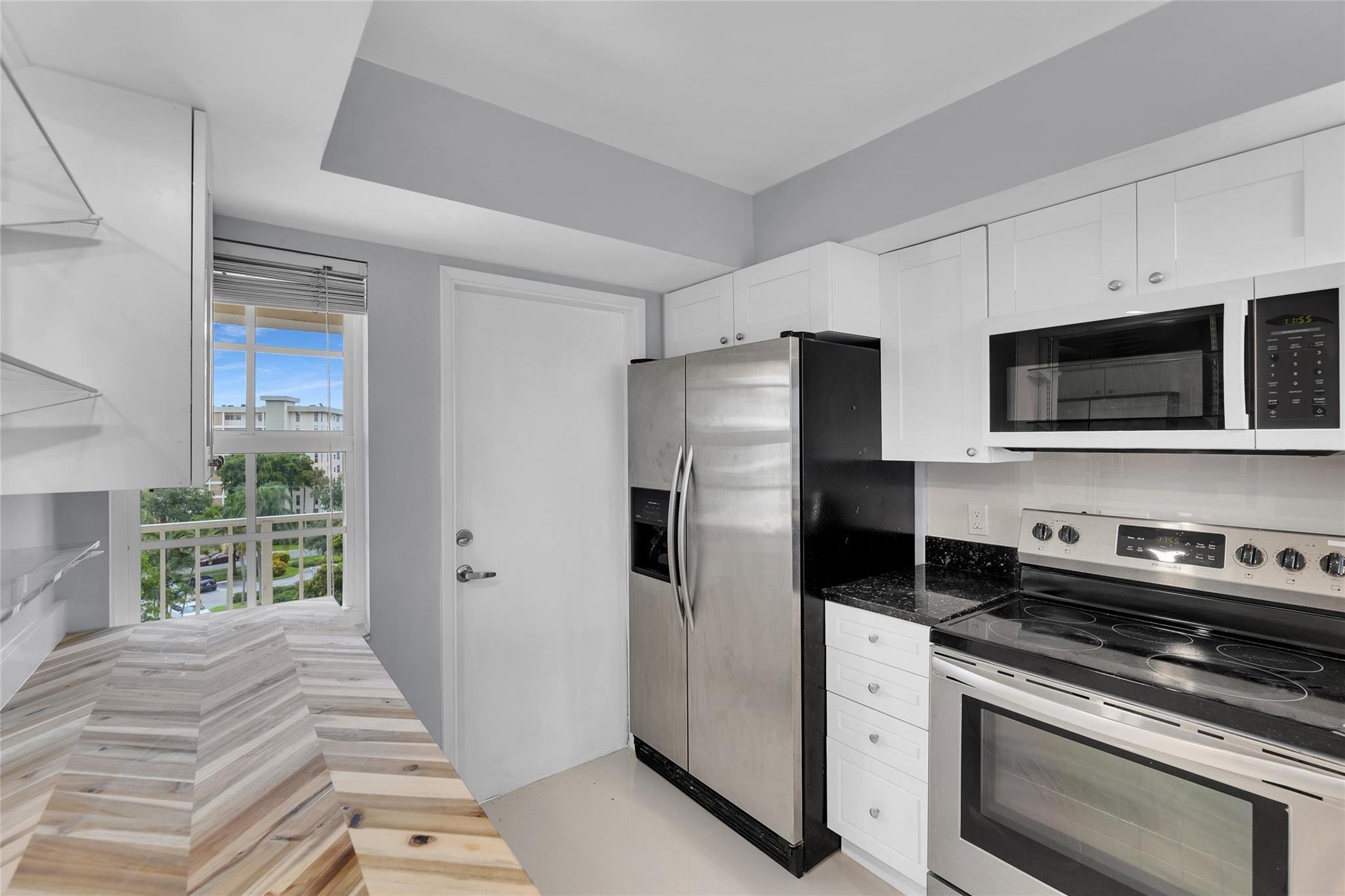 3090 North Course Drive, Unit 609 Pompano Beach, FL 33069 - Photo 5 of 44 a kitchen with stainless steel appliances a refrigerator a stove a microwave and cabinets