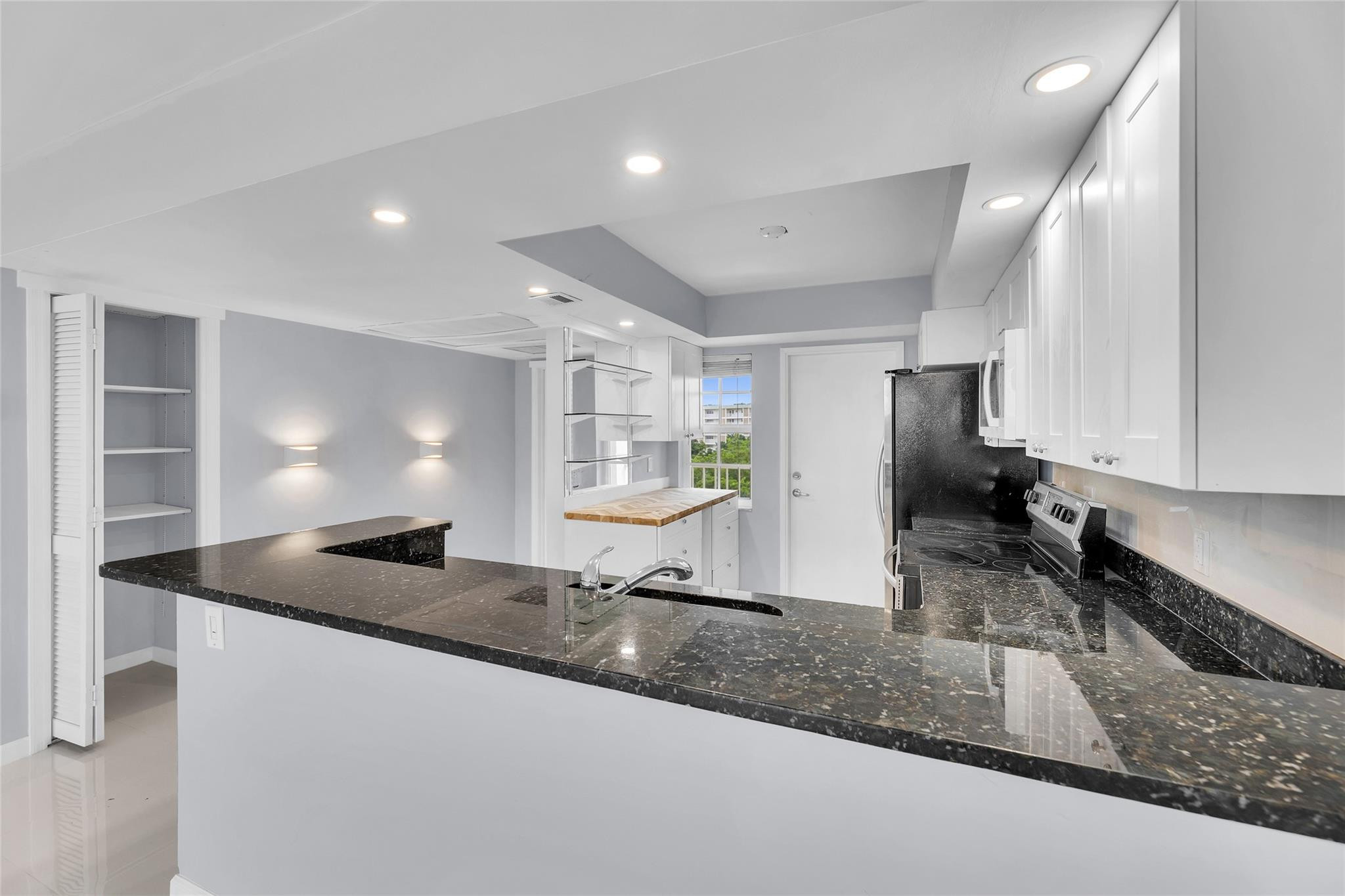 3090 North Course Drive, Unit 609 Pompano Beach, FL 33069 - Photo 7 of 44 a kitchen with granite countertop a sink a counter top space and cabinets