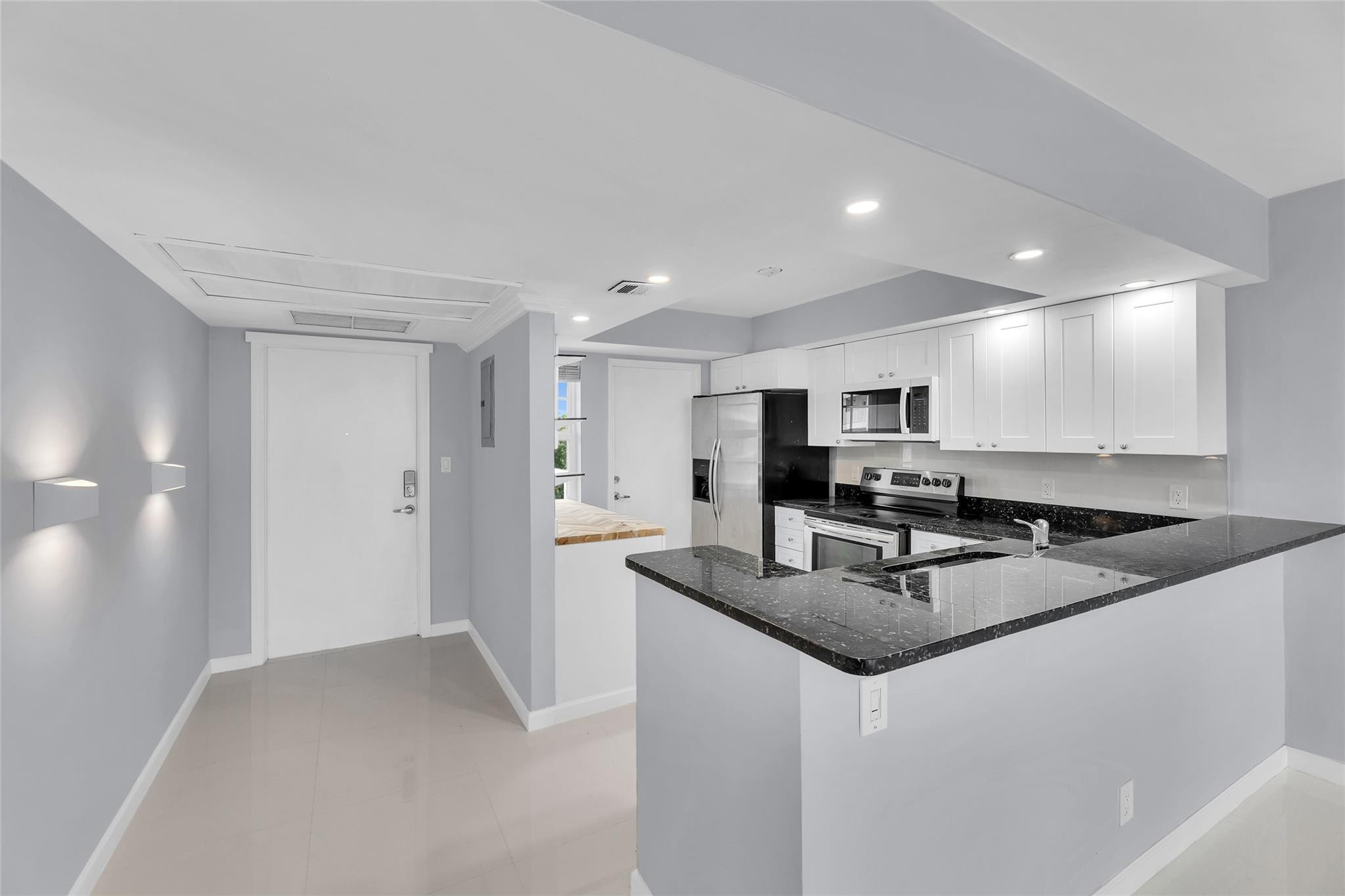 3090 North Course Drive, Unit 609 Pompano Beach, FL 33069 - Photo 8 of 44 a kitchen with stainless steel appliances granite countertop a sink and a refrigerator