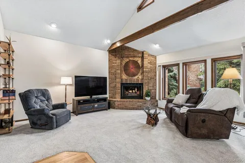 a living room with furniture a flat screen tv and a large window