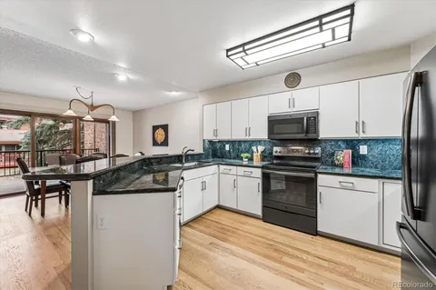 a kitchen with granite countertop a sink stainless steel appliances and cabinets