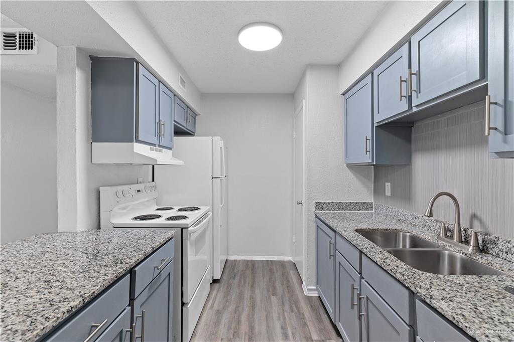 2425 Barnard Road, Unit A15 Brownsville, TX 78520 - Photo 6 of 16 Kitchen featuring light hardwood / wood-style floors, a textured ceiling, light stone counters, white electric stove, and sink