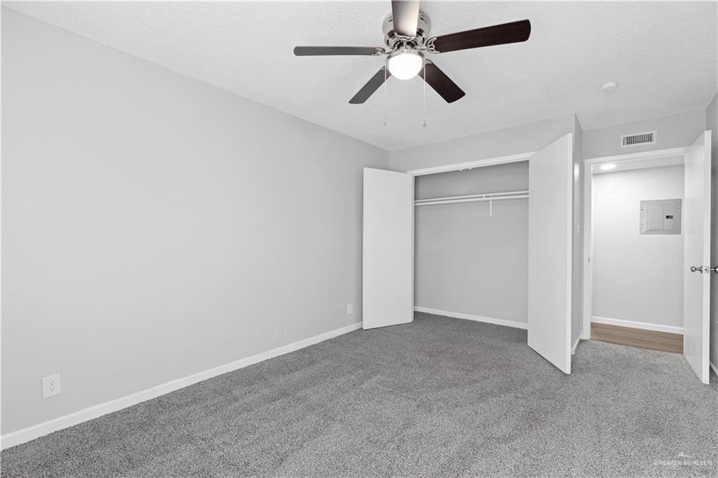 2425 Barnard Road, Unit A15 Brownsville, TX 78520 - Photo 8 of 16 Unfurnished bedroom with dark colored carpet, ceiling fan, and a closet