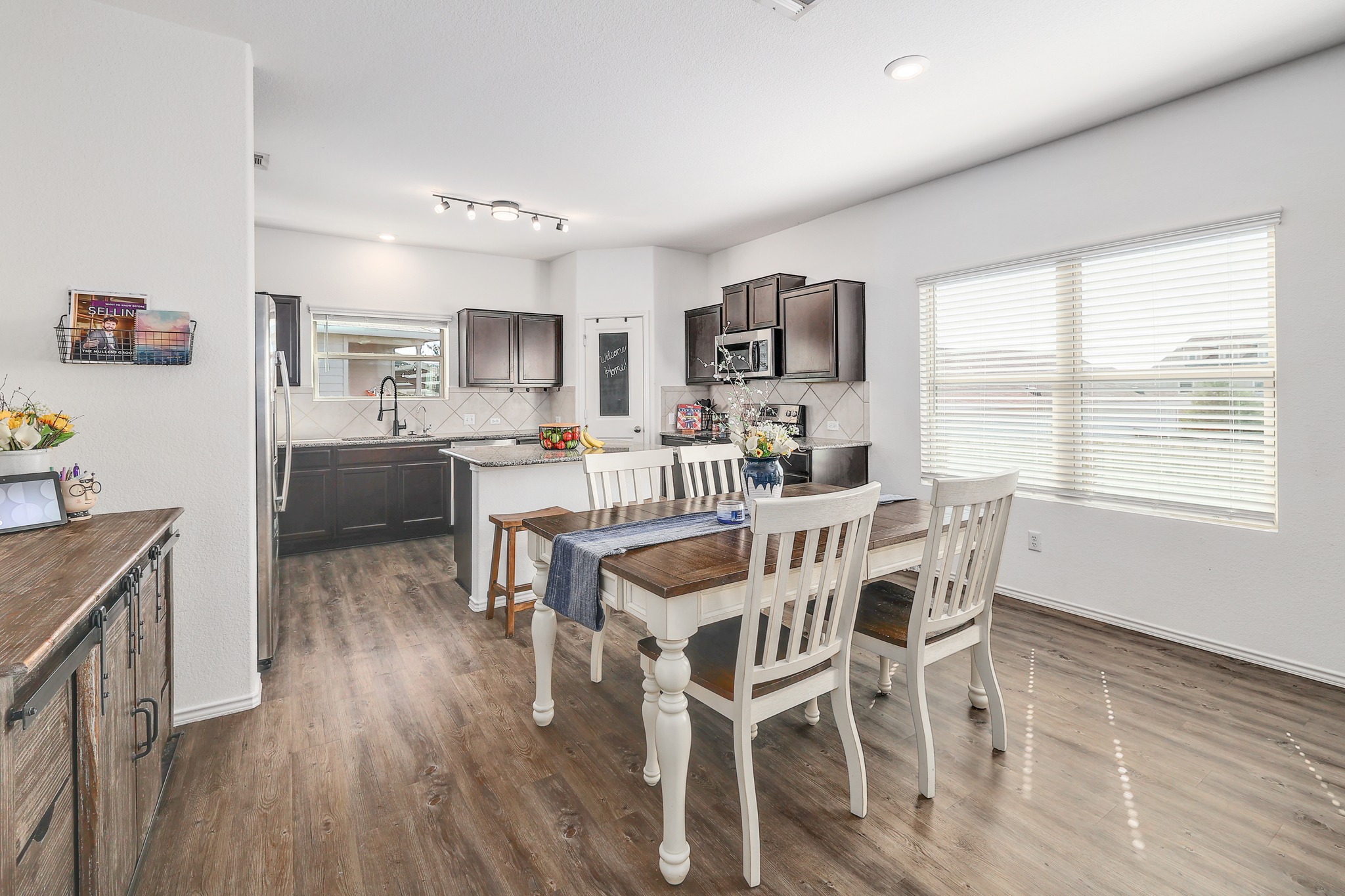 735 Circle Way Jarrell, TX 76537 - Photo 4 of 32 Rich wood-look flooring connects this casual dining space with the adjacent kitchen.