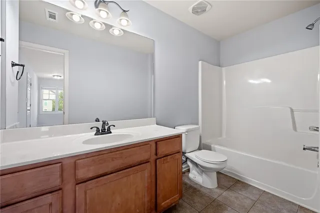 a bathroom with a sink a toilet a mirror and shower