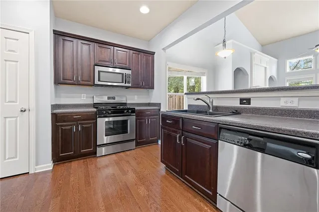 a kitchen with stainless steel appliances granite countertop wooden cabinets and a stove top oven