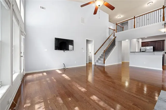 a view of a livingroom with wooden floor and a ceiling fan