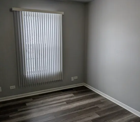 a view of a room with wooden floor and a window