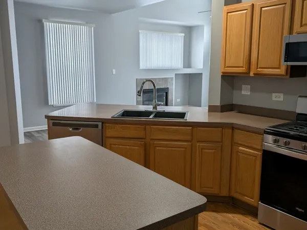 a kitchen with kitchen island granite countertop a sink stove and cabinets