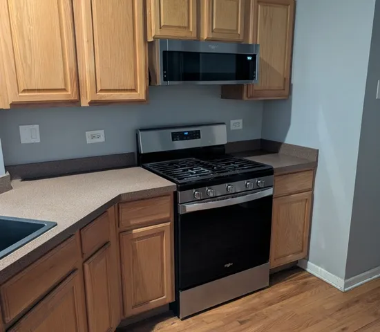a kitchen with stainless steel appliances a stove and a microwave