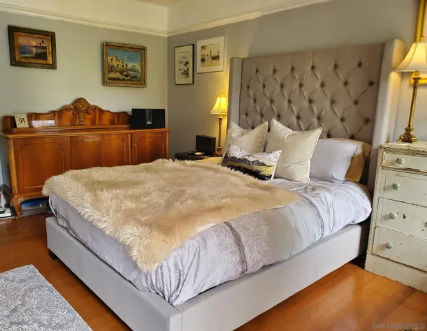a bedroom with a bed and wooden floor