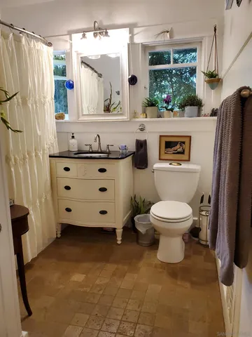 a bathroom with a toilet a sink and a mirror