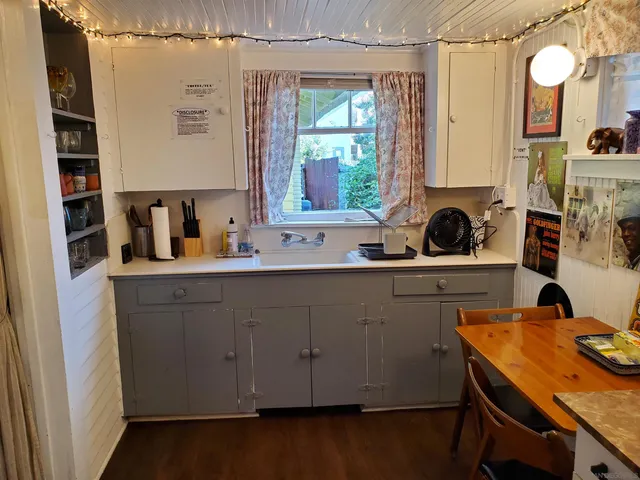 a view of a chairs and table in the back yard of a house