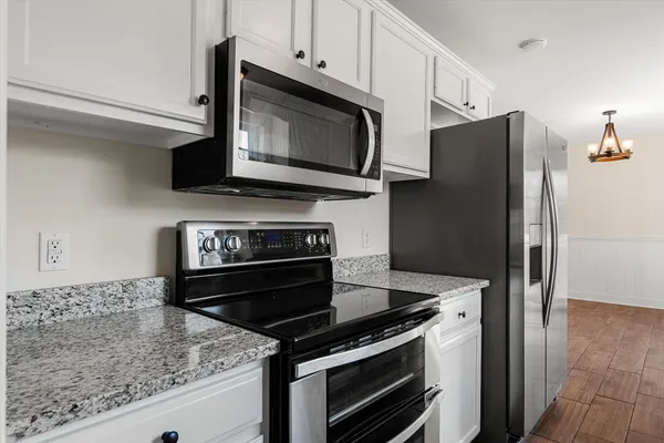 a kitchen with granite countertop white cabinets and a sink