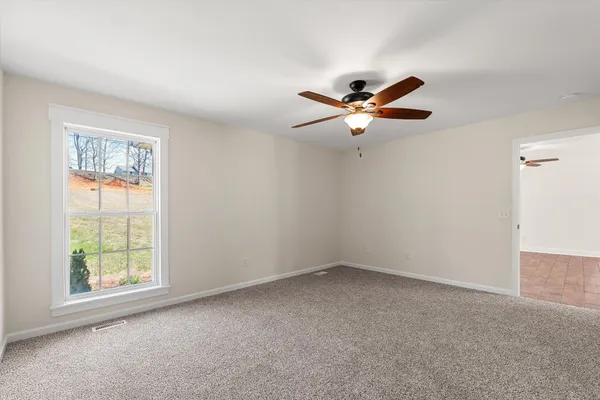 an empty room with closet and a ceiling fan