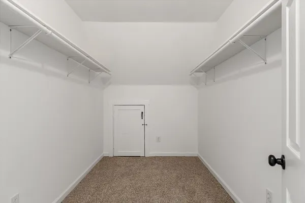 an empty room with wooden floor white walls and windows