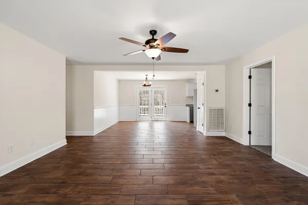 a view of a livingroom with wooden floor and a ceiling fan