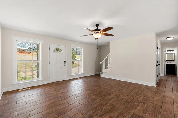 a view of a kitchen with wooden floor and a window