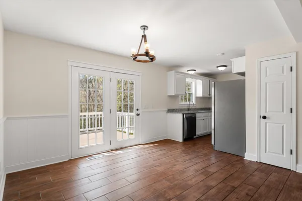 a kitchen with granite countertop a sink a window and cabinets