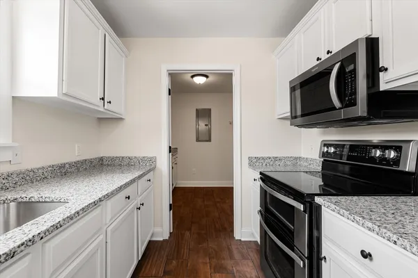 a kitchen with stainless steel appliances granite countertop a stove a refrigerator and a microwave