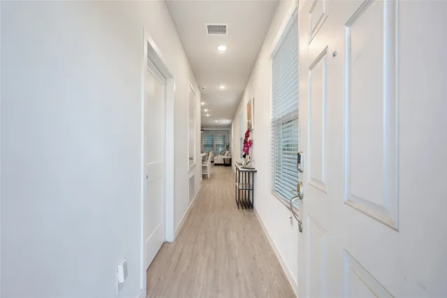 a view of a hallway with wooden floor and staircase