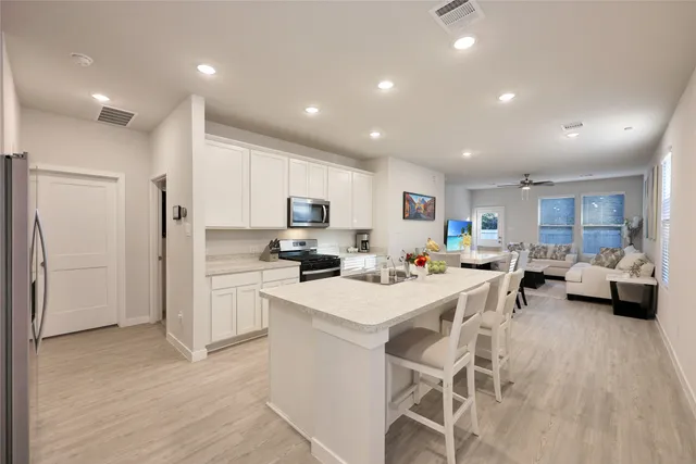 a kitchen that has a lot of cabinets a sink and appliances