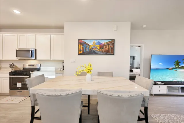 a kitchen with a sink a stove and chairs