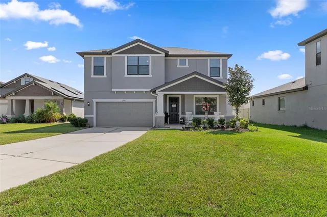a front view of a house with garden and chairs