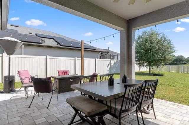 a view of a patio with a table chairs and backyard