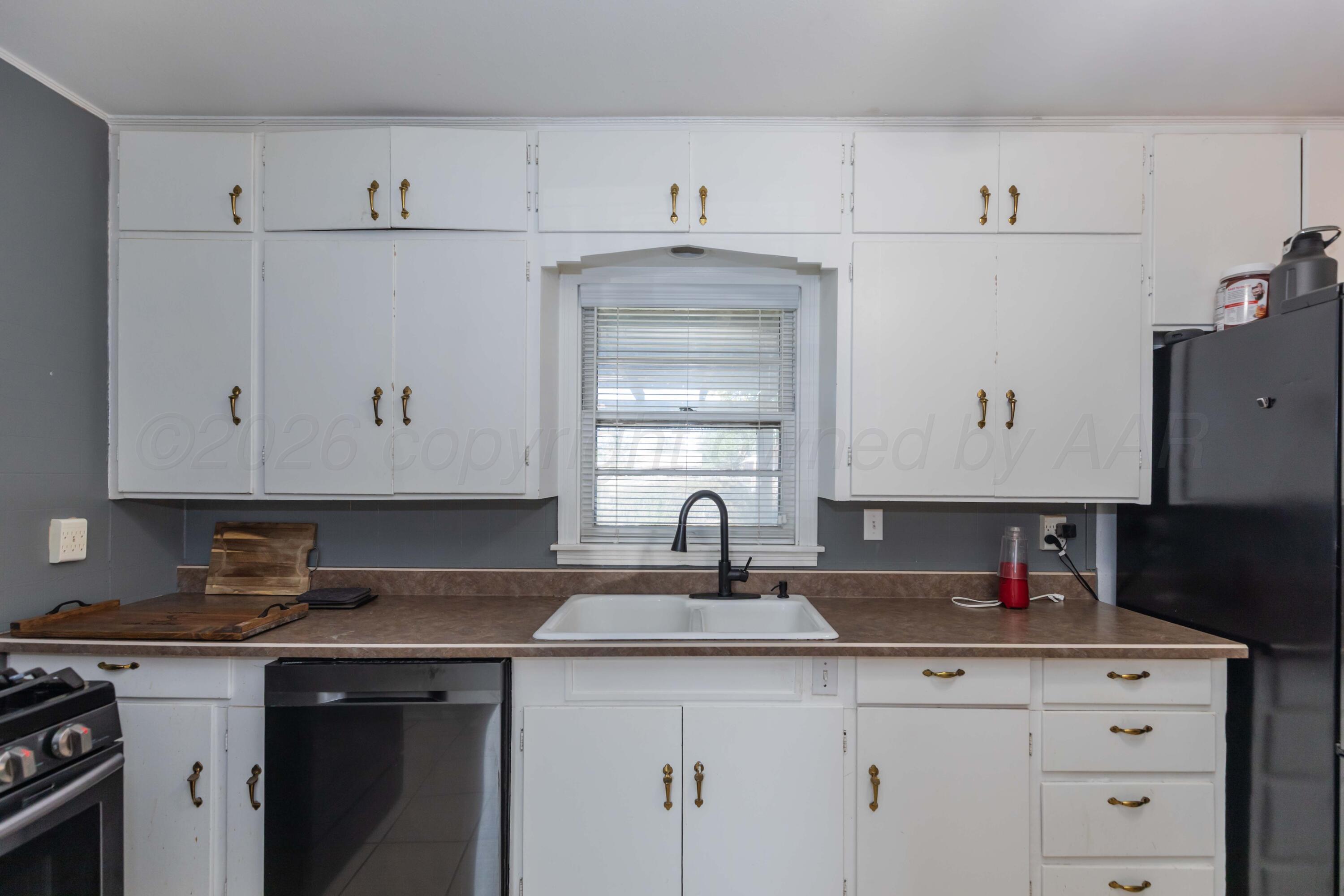 1602 Mustang Street Amarillo, TX 79102 - Photo 13 of 36 a kitchen with granite countertop white cabinets and sink