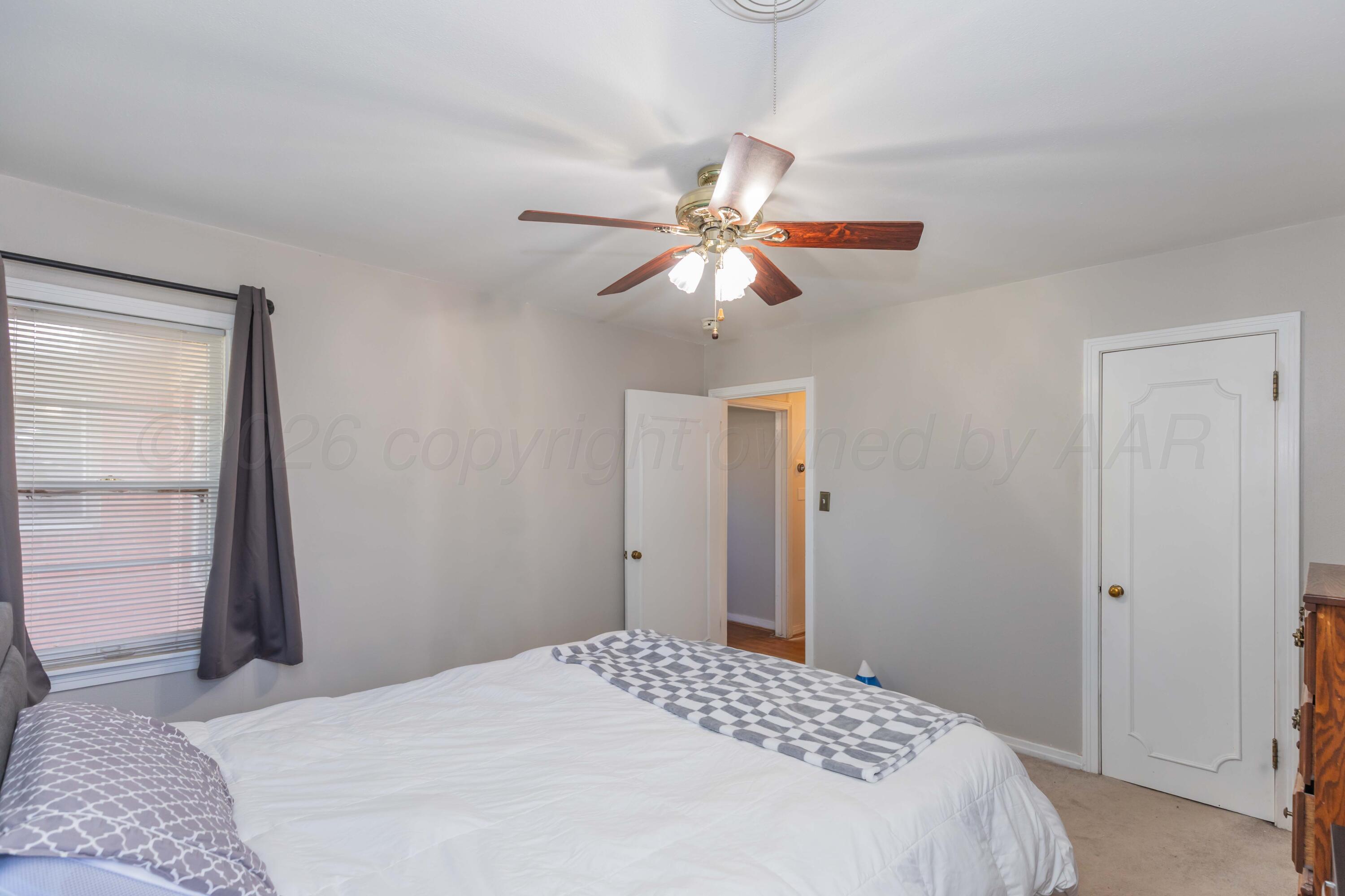 1602 Mustang Street Amarillo, TX 79102 - Photo 23 of 36 a bedroom with a large bed and a chandelier
