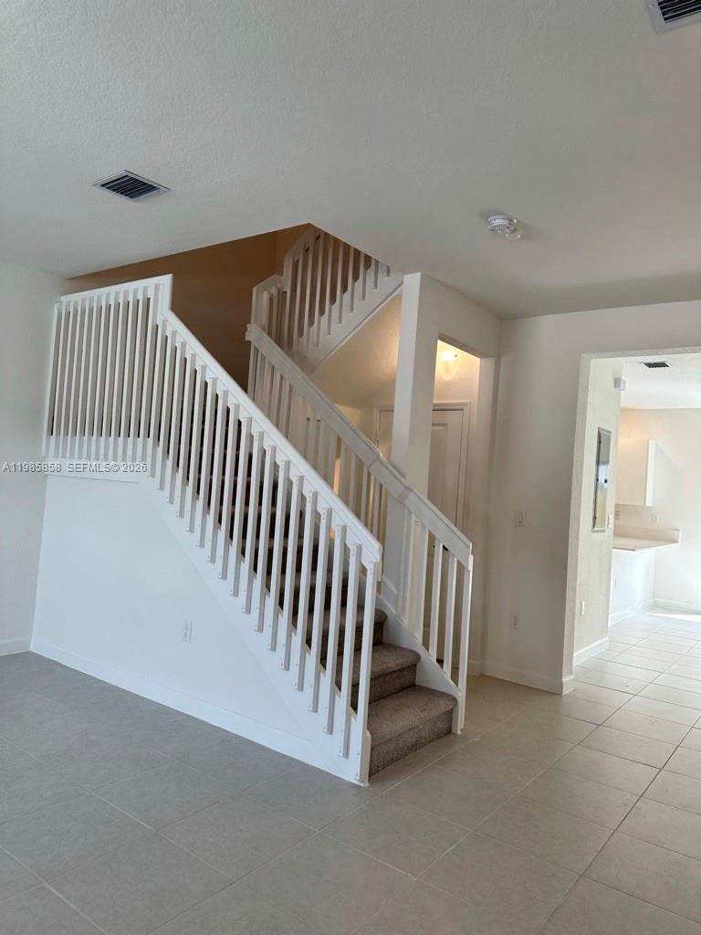 13254 Southwest 285th Street, Unit 13254 Homestead, FL 33033 - Photo 2 of 10 a view of staircase with white walls and stairs