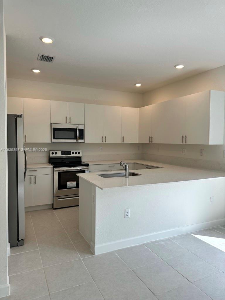 13254 Southwest 285th Street, Unit 13254 Homestead, FL 33033 - Photo 3 of 10 a kitchen with a sink stainless steel appliances and cabinets