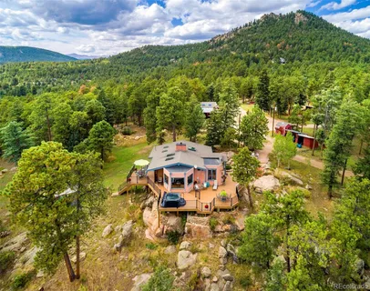 a aerial view of a house with swimming pool and trees in the background